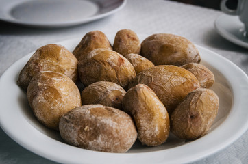 Papas arrugadas - small canarian wrinkly potatoes with salt on a plate close up. Brewed in sea water