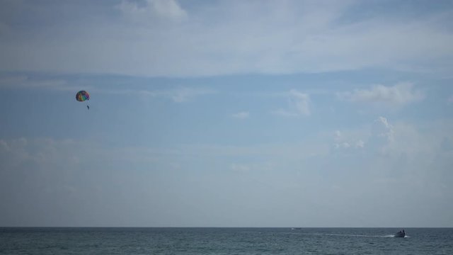 4k video of traveler parasailing with speed boat over the sea