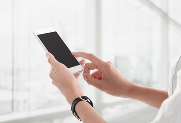 Woman hands holding and using smartphone with blank screen for your text or advertising isolated on...