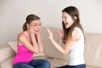 Happy woman yelling while showing her precious engagement ring on finger to her surprised...