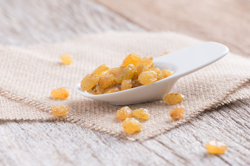Dried yellow raisin fruits on  wood background