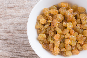 Dried yellow raisin fruits on  wood background