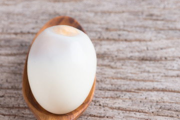 Peeled boiled egg on wood background