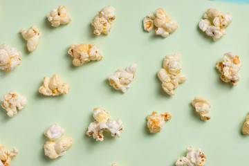 The popcorn in paper cup on green background.