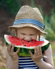 The little girl greedily eating a big watermelon