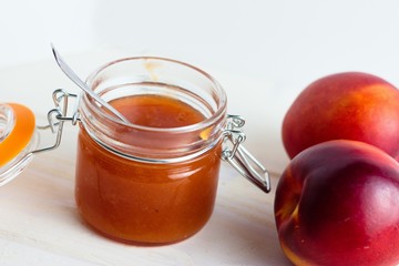 Homemade jam made of peaches and nectarines in rustic glass jar
