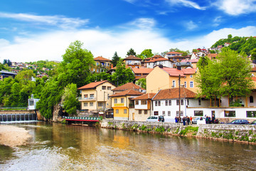 Naklejka na ściany i meble View of the architecture and embankment of the Milyacki River in the historical center of Sarajevo, Bosnia and Herzegovina on JUNE 12, 2016 in Sarajevo.