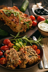 Meatloaf, greek style kitchen, on black background.