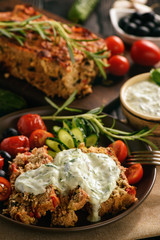 Meatloaf, greek style kitchen, on black background.