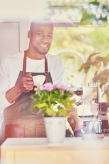 Black bearded coffee seller pouring coffee.