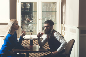 Man and woman drinking from martini glasses
