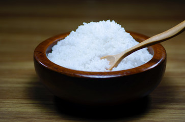 salt on wooden spoon and wooden bowl