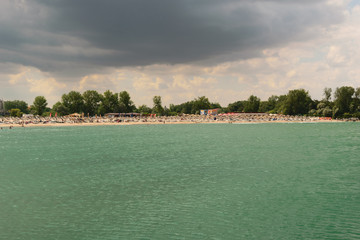 Neptun, Romania - July 8, 2017: The Black Sea changes color to turquoise due to a natural but very rare phenomenon caused by microorganism. In the background is the beach resort in  Constanta, Romania © Florin
