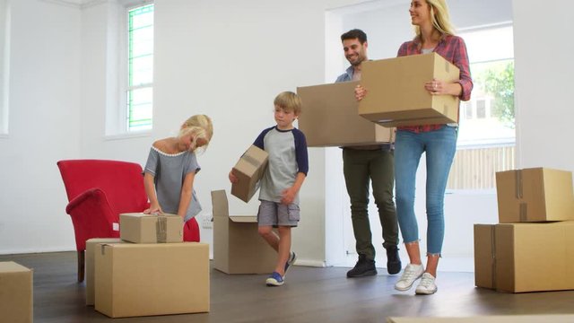 Family Unpacking Boxes In New Home On Moving Day