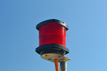 Red separated lamp with orange wire and blue sky 