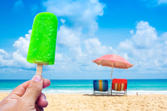 Hand Holding Popsicle Background The Sea And Blue Sky.