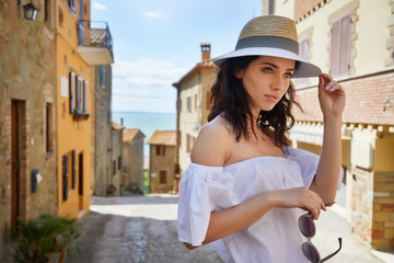 Naklejka premium attractive woman tourist with hat in old italian town