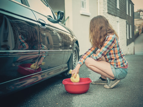Young woman washing her car