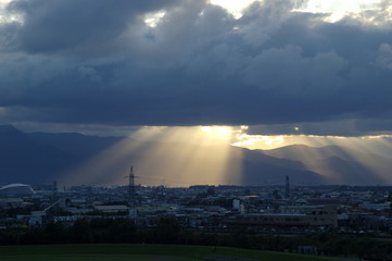黒雲から陽がさす札幌郊外の街