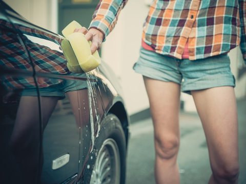 Young woman washing her car
