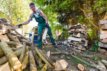 Mann verarbeitet Brennholz | Handwerker macht Holzstapel