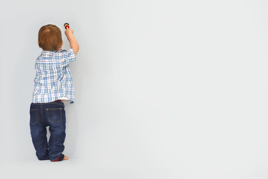 Cute little kid drawing painting brush on wall background