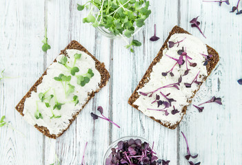 Wooden table with healthy food (slice of bread, cream cheese and fresh cutted cress)