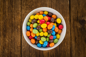 Cocolate coated Peanuts on wooden background (selective focus)
