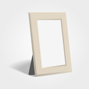 Realistic wooden picture or photo frame mock up standing on light background.