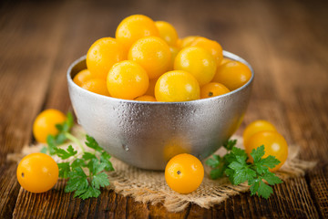 Yellow Tomatoes on wooden background; selective focus