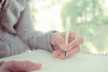 woman writing paper on left hand. business. write something on notebook