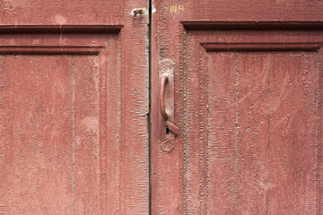 A slightly opened keyhole of an red wooden door