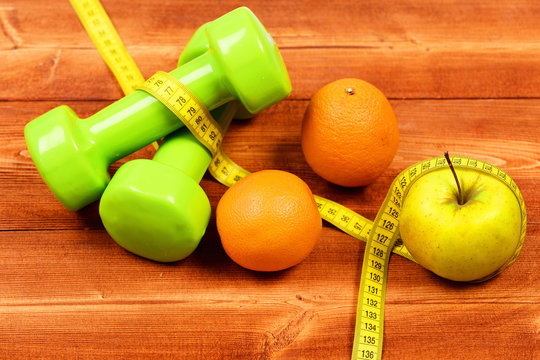aerobic concept, dumbbells weight with measuring tape, fruit