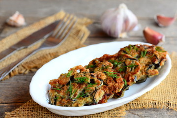 Fried eggplant burgers with dill and garlic on a white plate. Homemade quick eggplant recipe. Vegetable burgers closeup