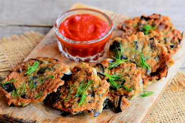 Fried eggplant burgers with dill and garlic on a wooden board. Home quick eggplant recipe. Vegetarian burgers closeup
