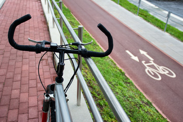 Bicycle on the background of city bike pathway with sign. Concept of safe city biking.
