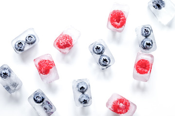 Obraz na płótnie Canvas ice cubes with fresh berries on white background top view