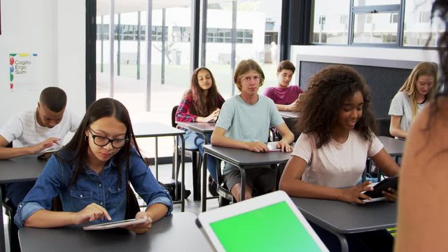 Teacher Uses Tablet In High School Class, Over Shoulder View