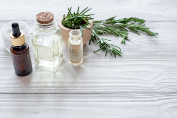 organic cosmetics with extracts of herbs rosemary on wooden back