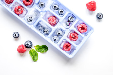 tray with berries ice cubes on white background top view