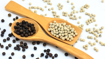 Peppercorn with wooden spoon on white background. Composition isolated over the white background.