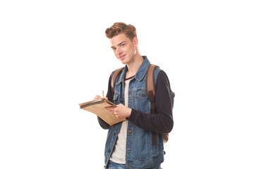 Portrait of schoolboy writing in notepad against white background