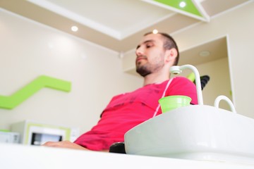 A young man sitting in a dental chair waiting for his teeth to be examined