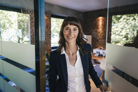 Businesswoman opening glass door