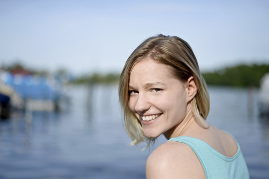 Portrait of smiling young woman in front of a lake