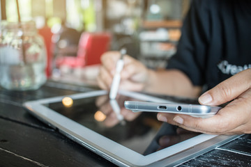 Using Online banking payment by network technology internet on wireless development mobile smartphone and tablet sync app with touch pen for Business  holding smart phone for shopping coffee shop