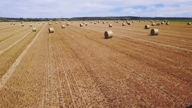 drone forward flight over field with hay bales.