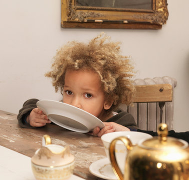 Young Boy Licking Plate