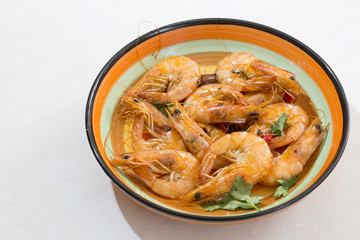 Delicious seafood shrimp with red pepper, coriander and olive oil made, and in a colorful  plate.