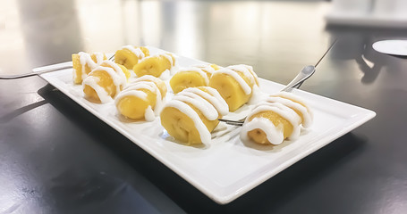 One of Exotic popular Thai dessert is Boiled bananas in syrup with coconut milk on top.